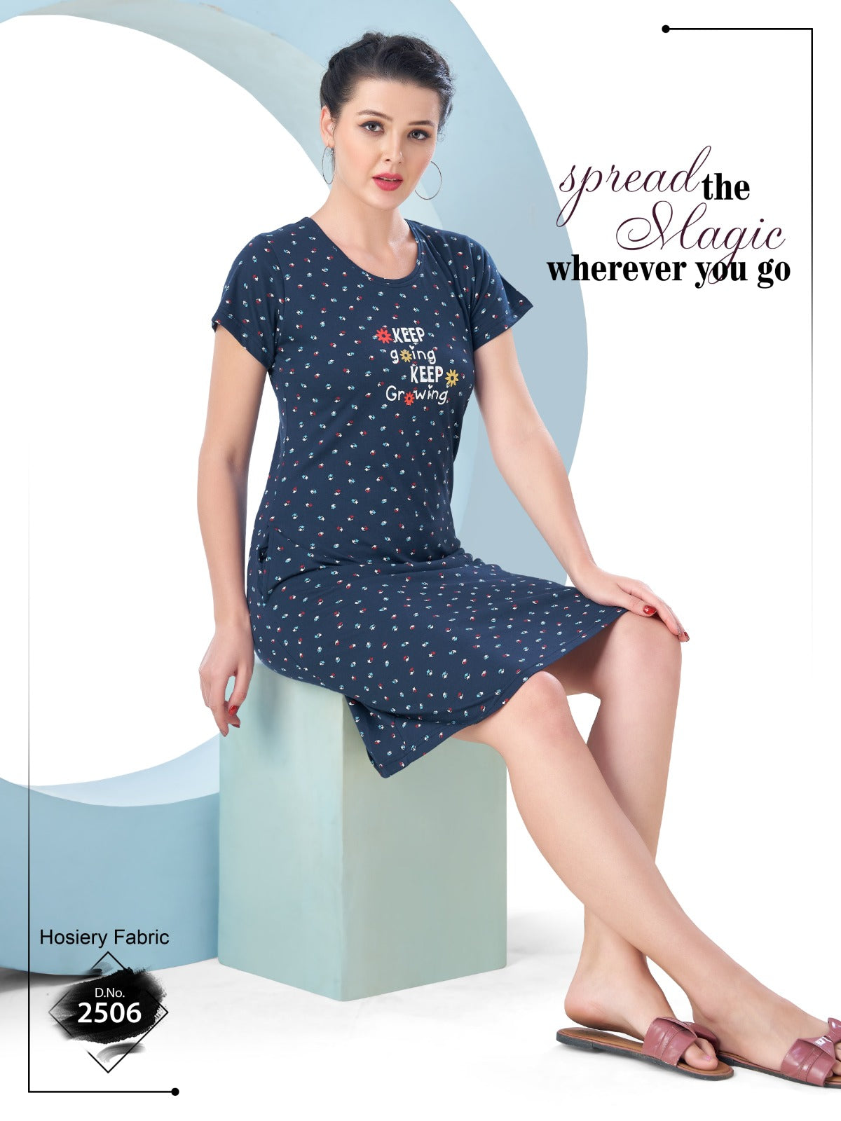 Woman wearing a navy blue nightgown with text design, sitting on a light blue block.