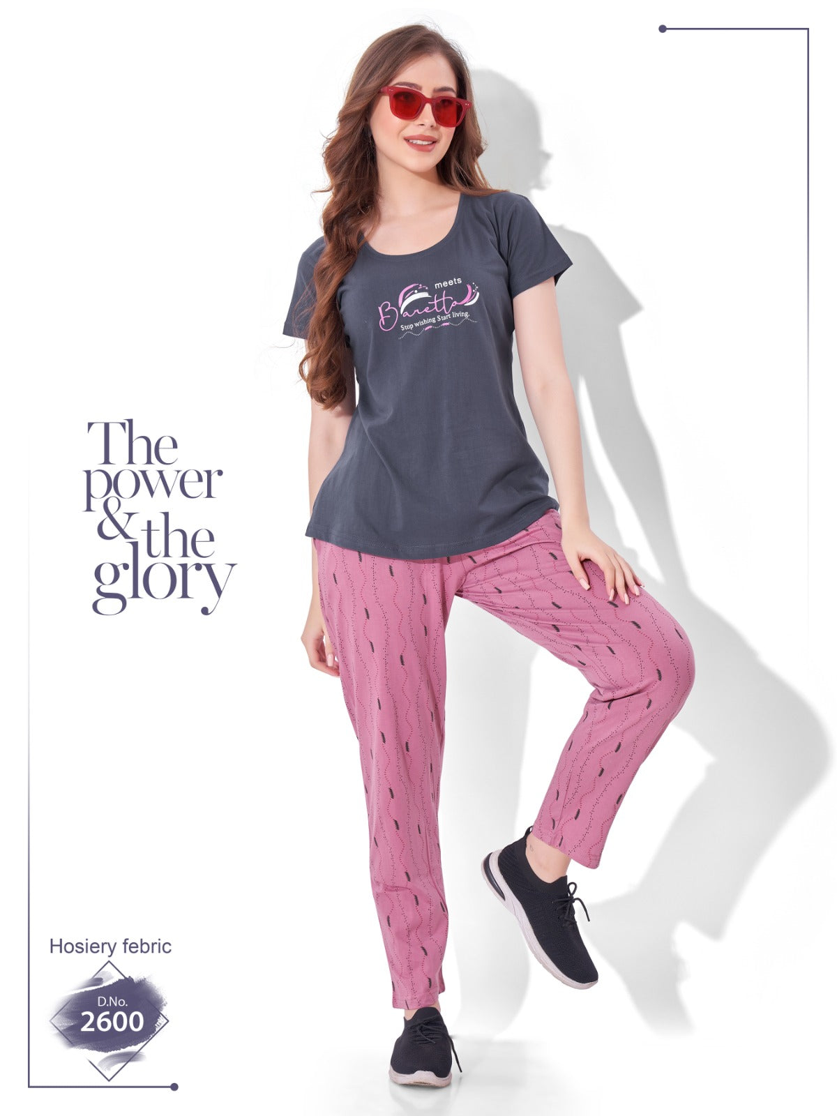 Woman wearing a dark gray t-shirt and pink pants with text 'The power & the glory' on a white background.