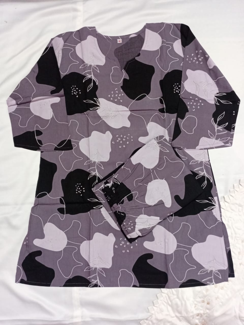 Long-sleeve shirt with black and white abstract pattern on a white background