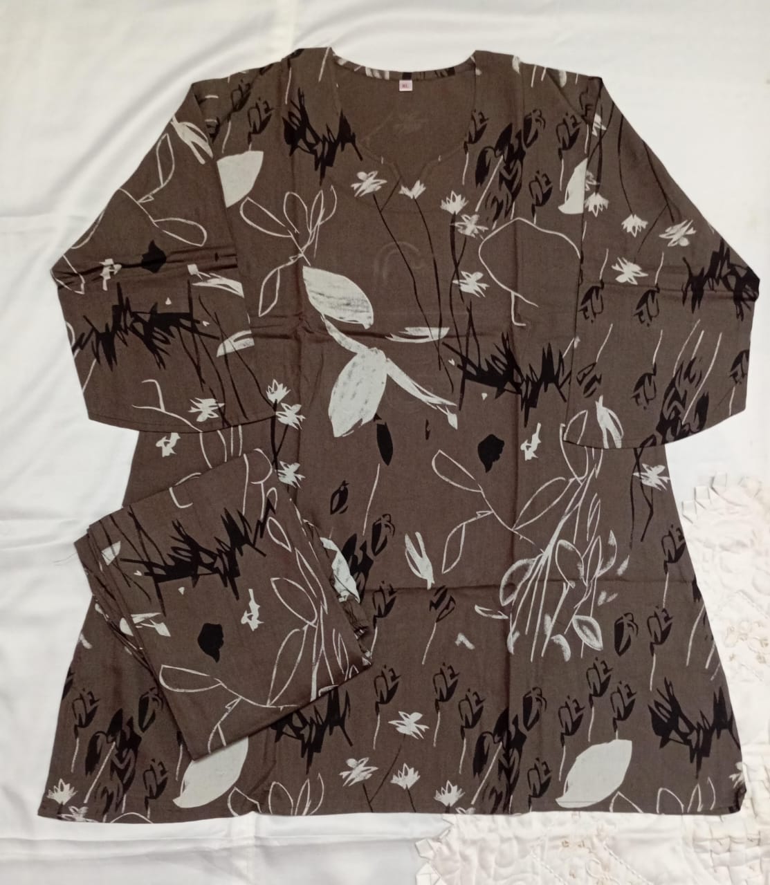 Brown dress with black and white floral pattern on a white background