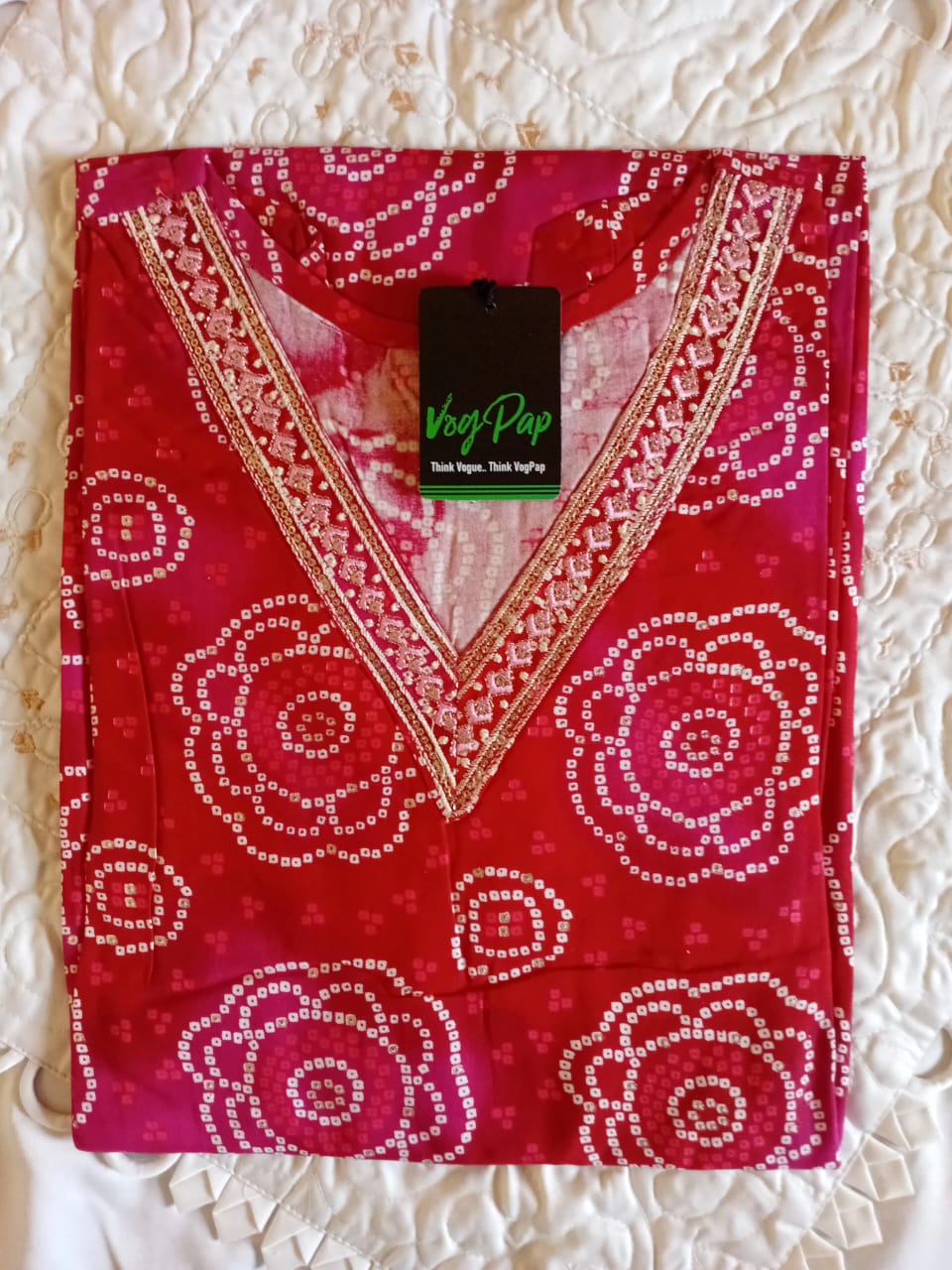Red patterned garment with a V-neck on a textured white background