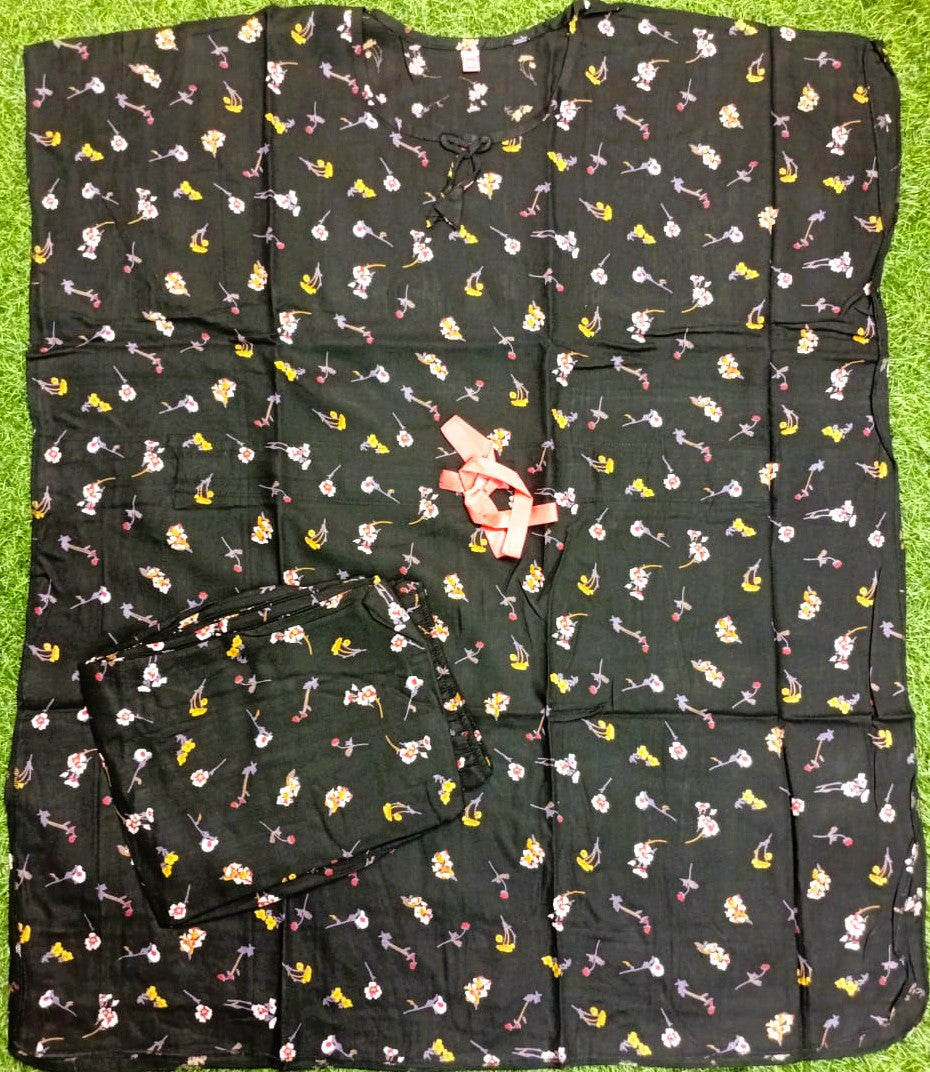 Black garment with colorful patterns laid flat on a green surface