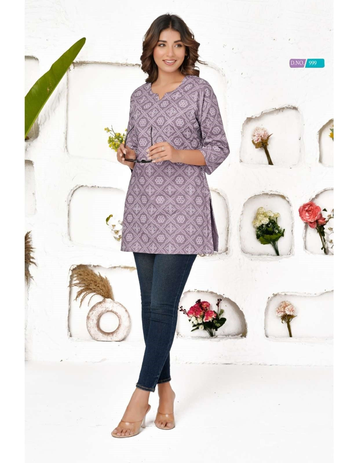 Woman wearing a patterned purple shirt and blue jeans against a decorative background with flowers and plants.