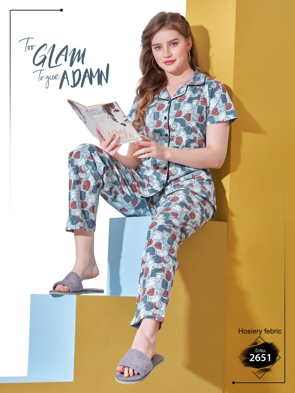 Woman in floral pajama set reading a magazine against a yellow wall.