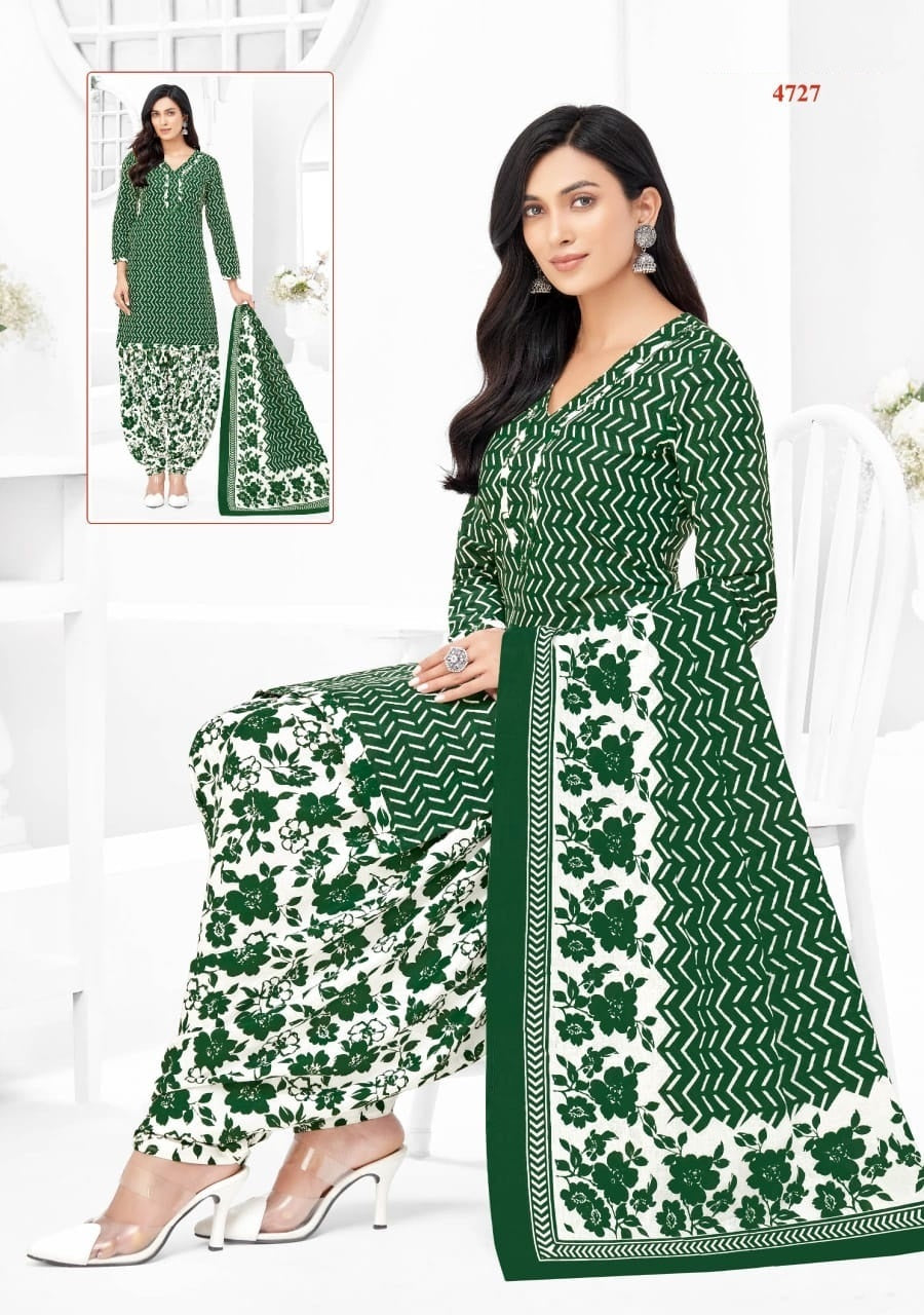 Woman wearing a green and white patterned dress with a matching dupatta, standing against a white background.