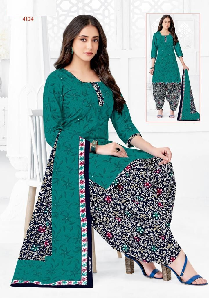 A woman modeling a fully stitched green cotton suit with floral print, consisting of a top and long pants.