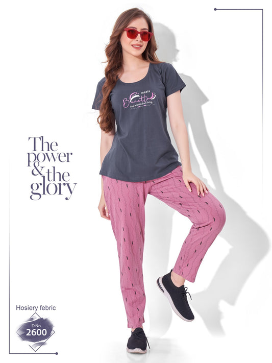 Woman wearing a dark gray t-shirt and pink pants with text 'The power & the glory' on a white background.