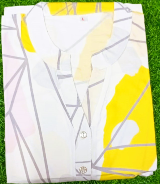White shirt with yellow and gray abstract pattern on a grass background