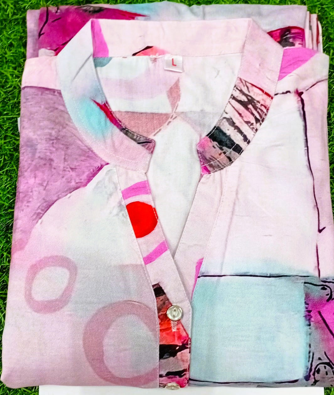Folded pink shirt with abstract patterns on a grass background