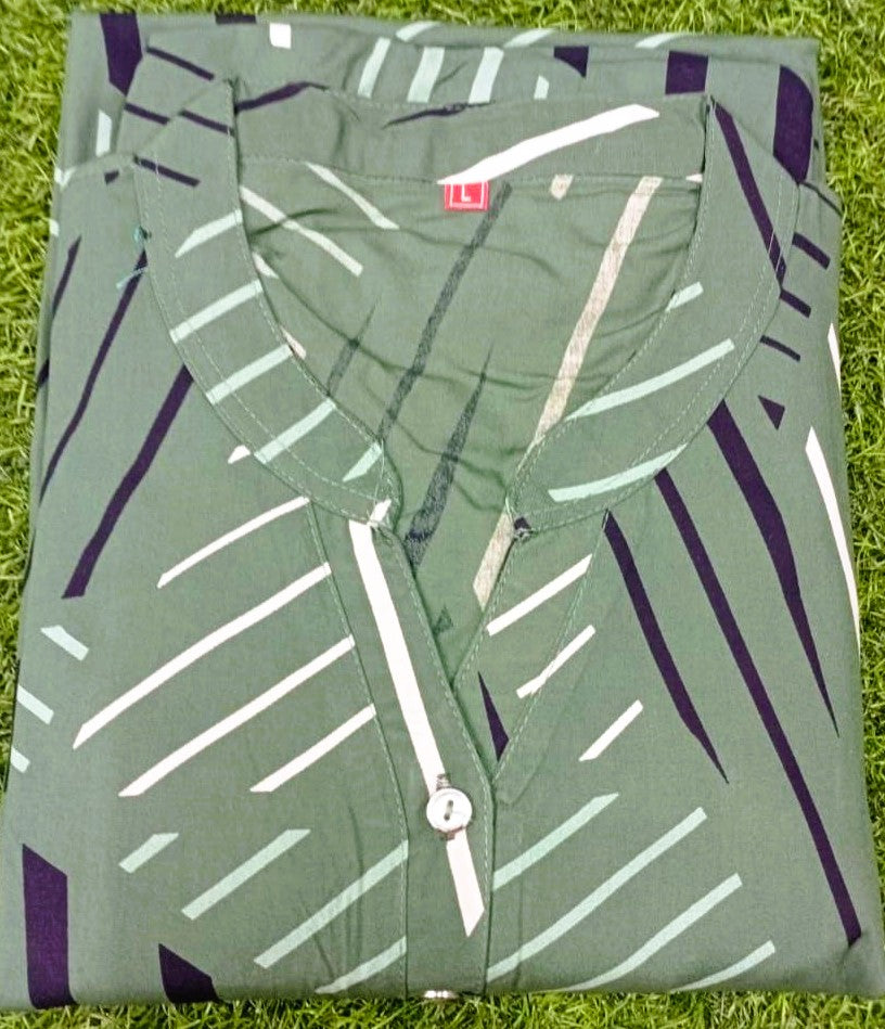 Folded green shirt with abstract pattern on a grassy background