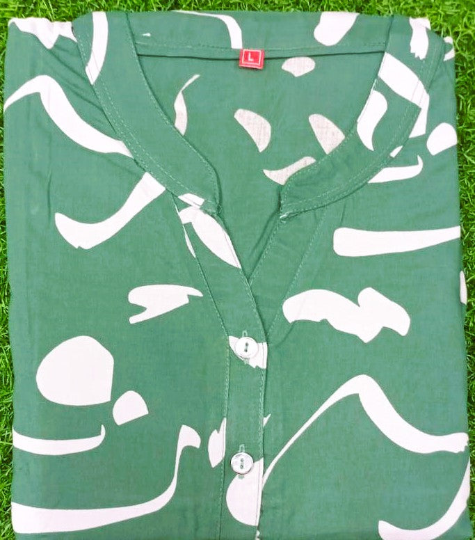 Green baby romper with white patterns on grass