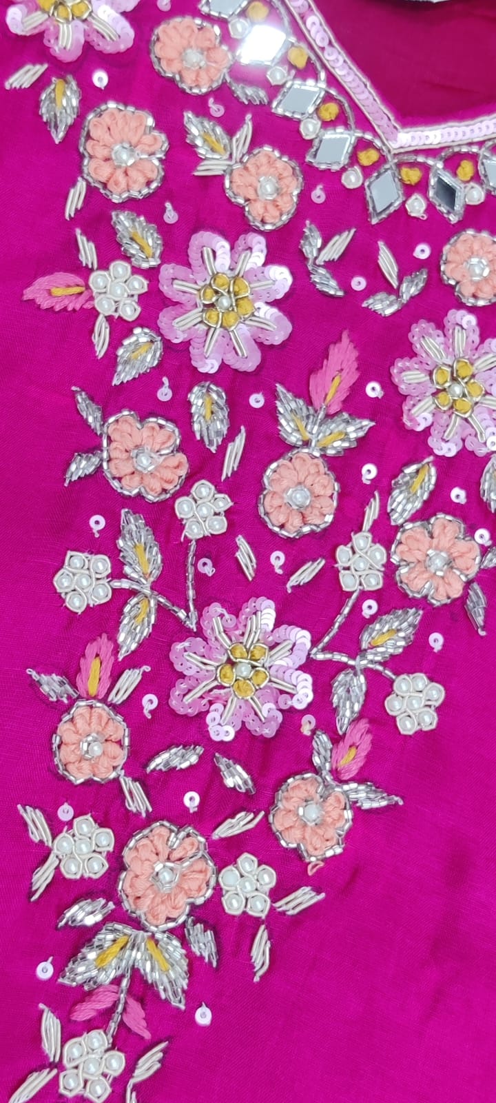 Embroidered fabric with floral patterns on a pink background