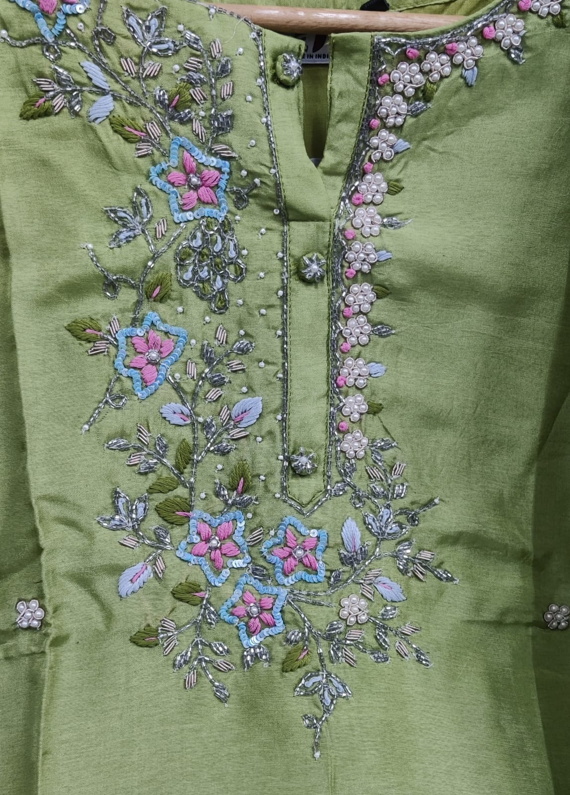 Green garment with intricate floral embroidery