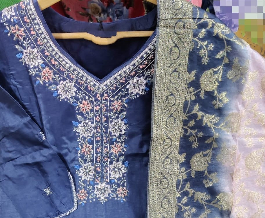 Blue embroidered garment on a hanger with a floral pattern