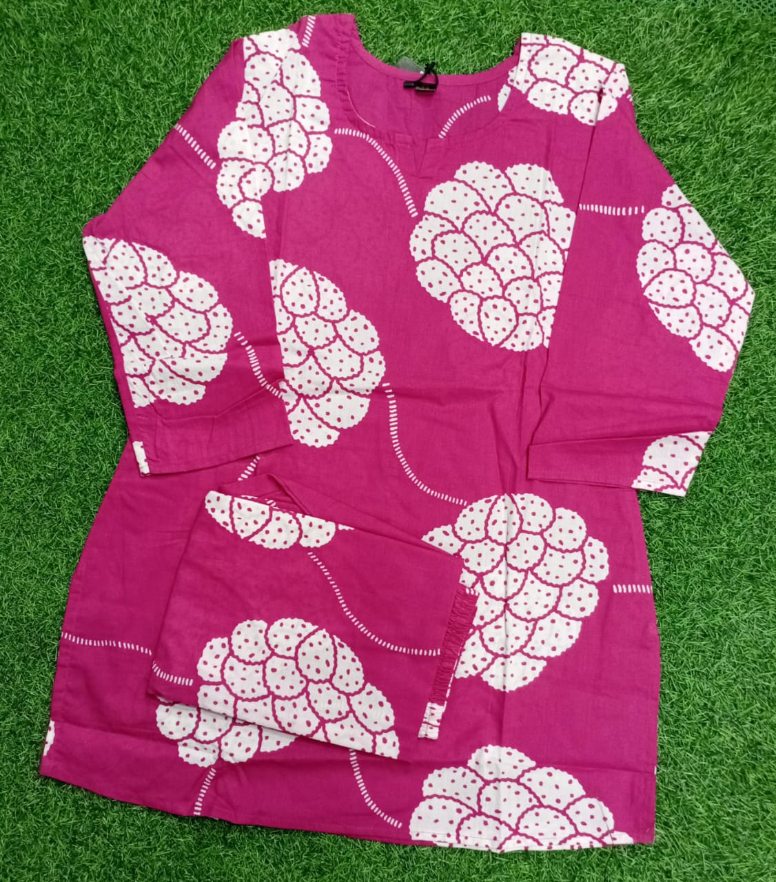 Pink outfit with white pattern on a green grass background