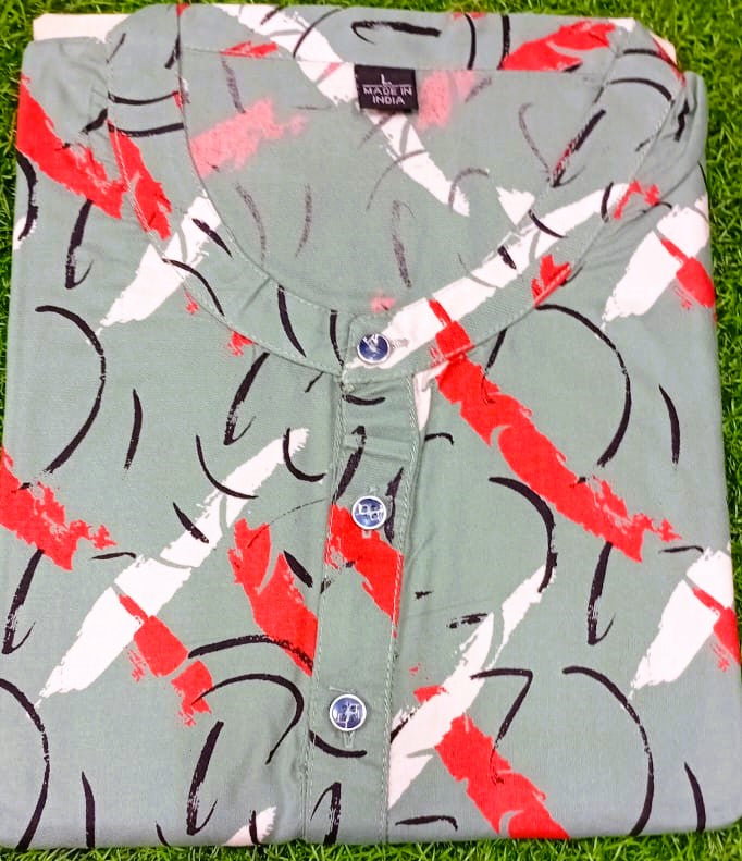 Folded shirt with red and black abstract pattern on a grass background