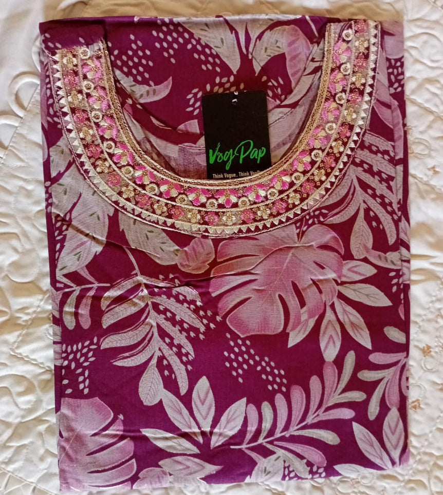 Pink floral-patterned top with decorative neckline on a textured surface