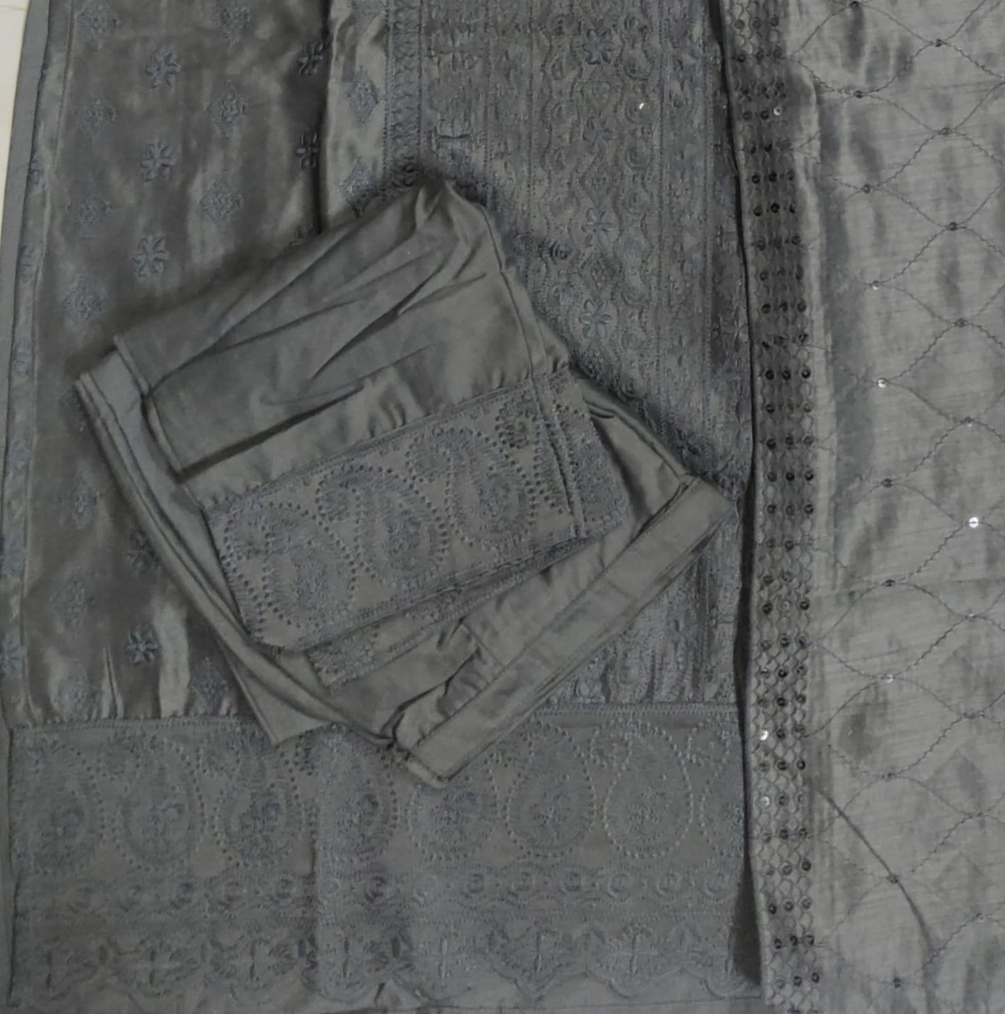 Folded dark gray fabric on a textured surface