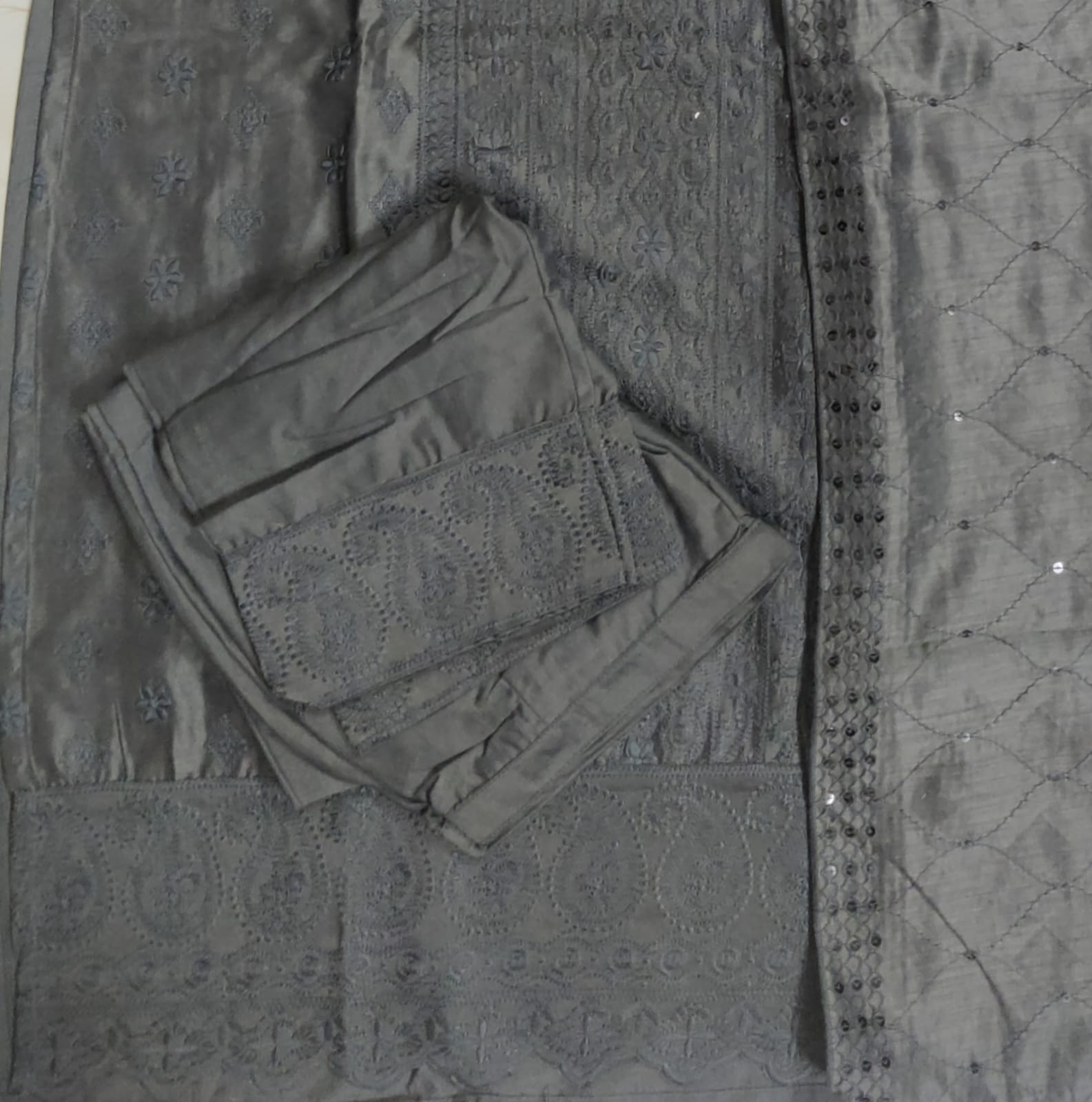 Folded dark gray fabric on a textured surface