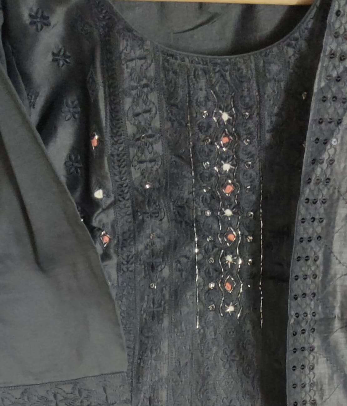 Dark fabric with intricate embroidery and beadwork