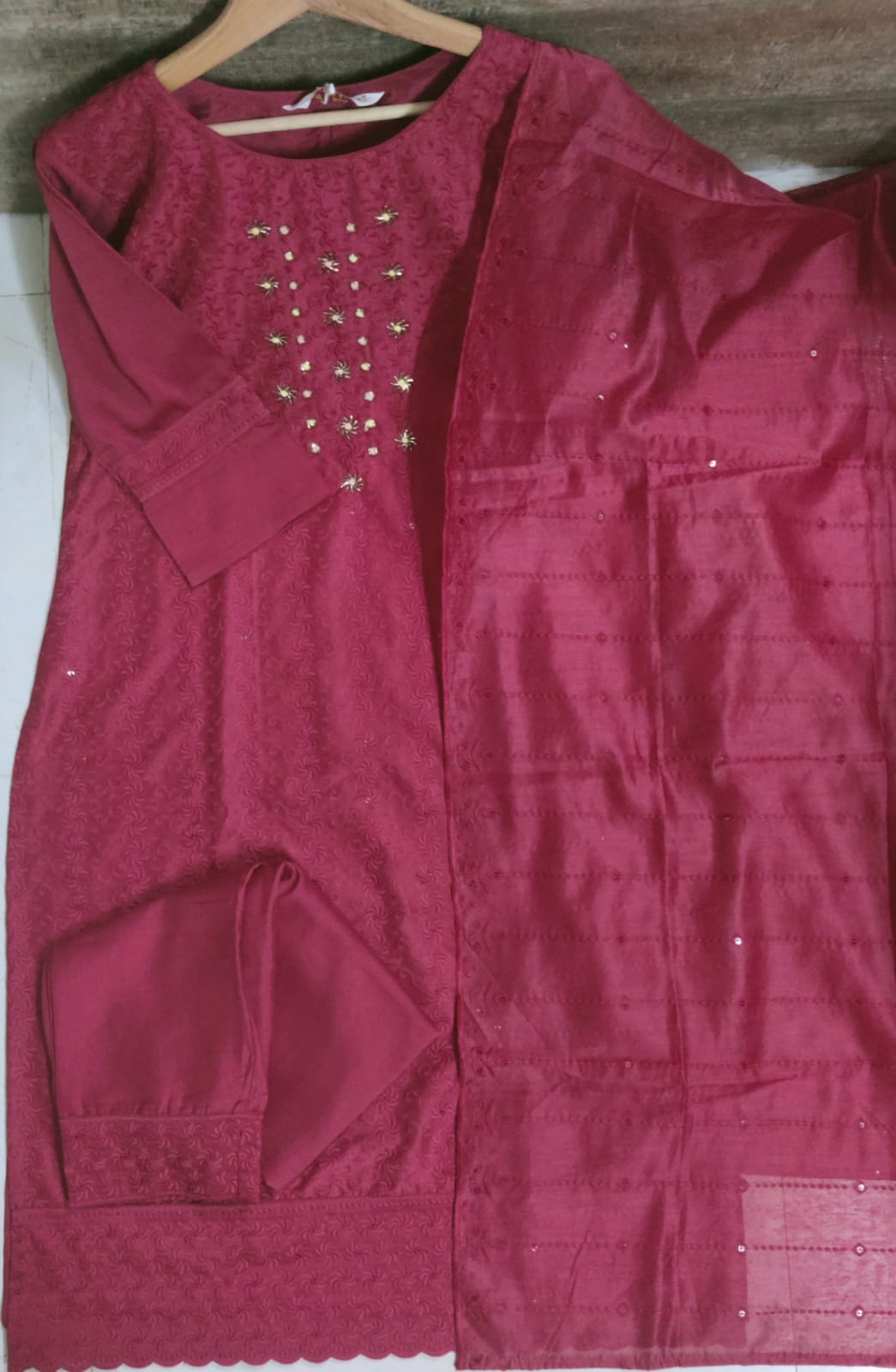 Maroon traditional outfit with embellishments on a white background