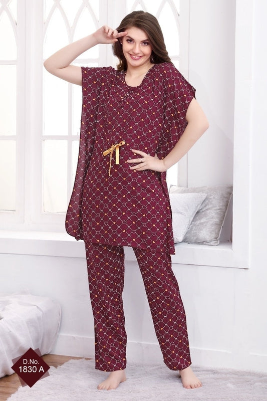 A woman standing in a room, wearing a maroon kaftan nightsuit set with geometric patterns, featuring a v-neckline and cap sleeves.