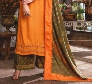 Orange and green traditional outfit with a patterned border on a wooden floor.