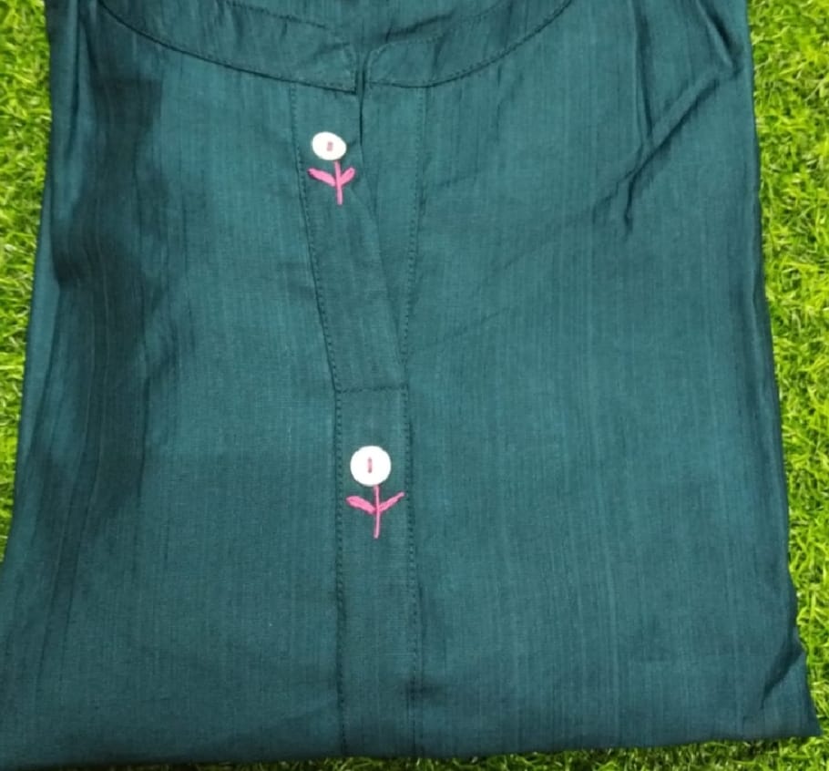 Teal fabric with embroidered flowers on a grassy background