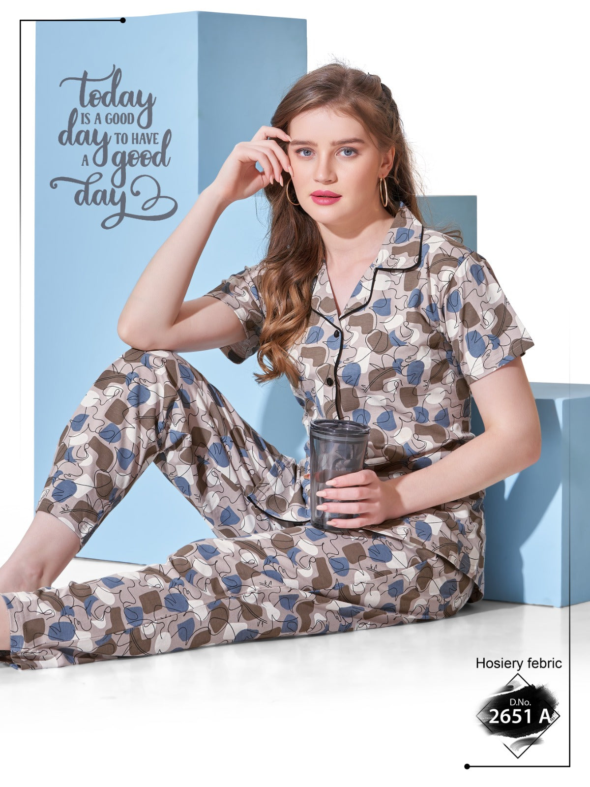 Woman wearing a patterned pajama set holding a cup, with a motivational quote in the background.