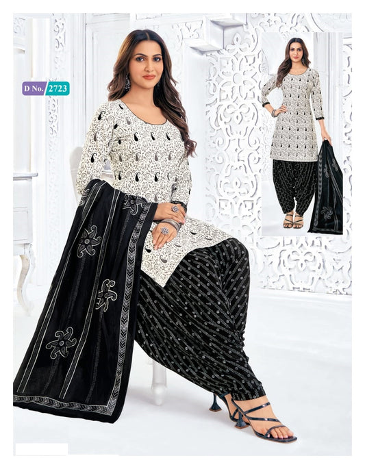 Woman wearing a black and white traditional outfit with a scarf, sitting on a white chair.