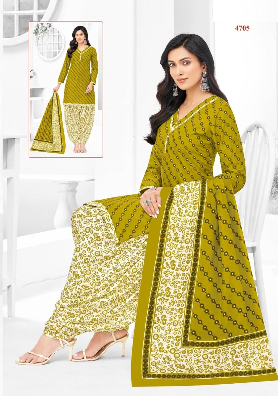 Woman wearing a green and white patterned saree with a matching blouse, sitting on a white chair.