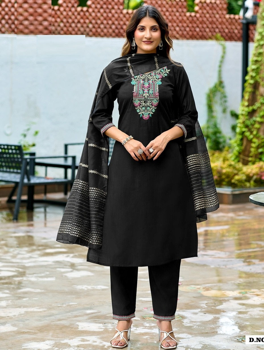 Woman wearing a black traditional outfit with floral embroidery in an outdoor setting.