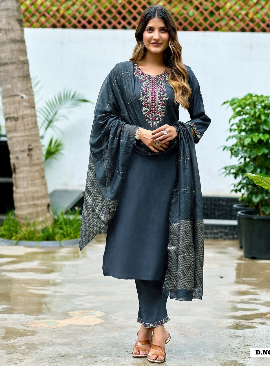 Woman wearing a dark blue traditional outfit with a patterned shawl outdoors.