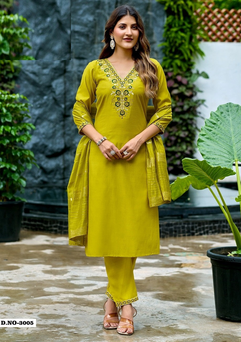 Woman wearing a yellow traditional outfit with intricate designs, standing outdoors.