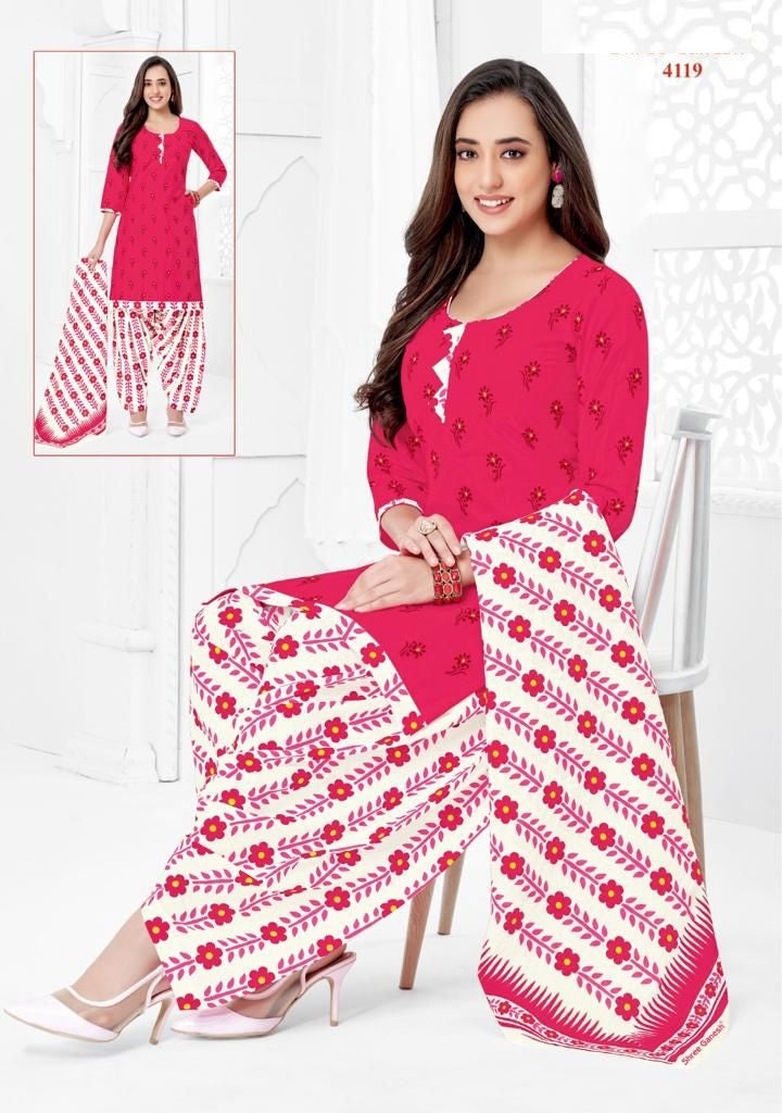 A woman wearing a red and white printed cotton fully stitched suit, consisting of a top and bottoms, along with a dupatta.