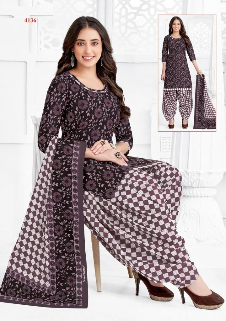 A woman wearing a floral print cotton fully stitched suit, consisting of a top and bottom with a dupatta.